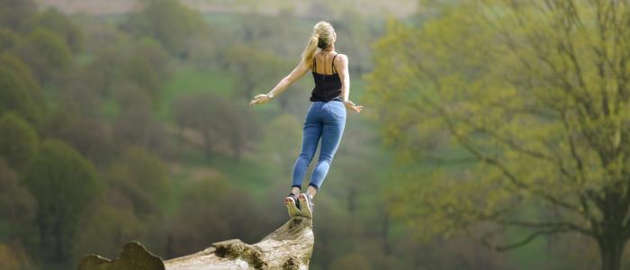 woman jumping off stump